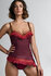 Model draagt de couture van Marlies Dekkers, een corset in rode pied de poule met franje en kettinkjes. het schouderbandje heef
